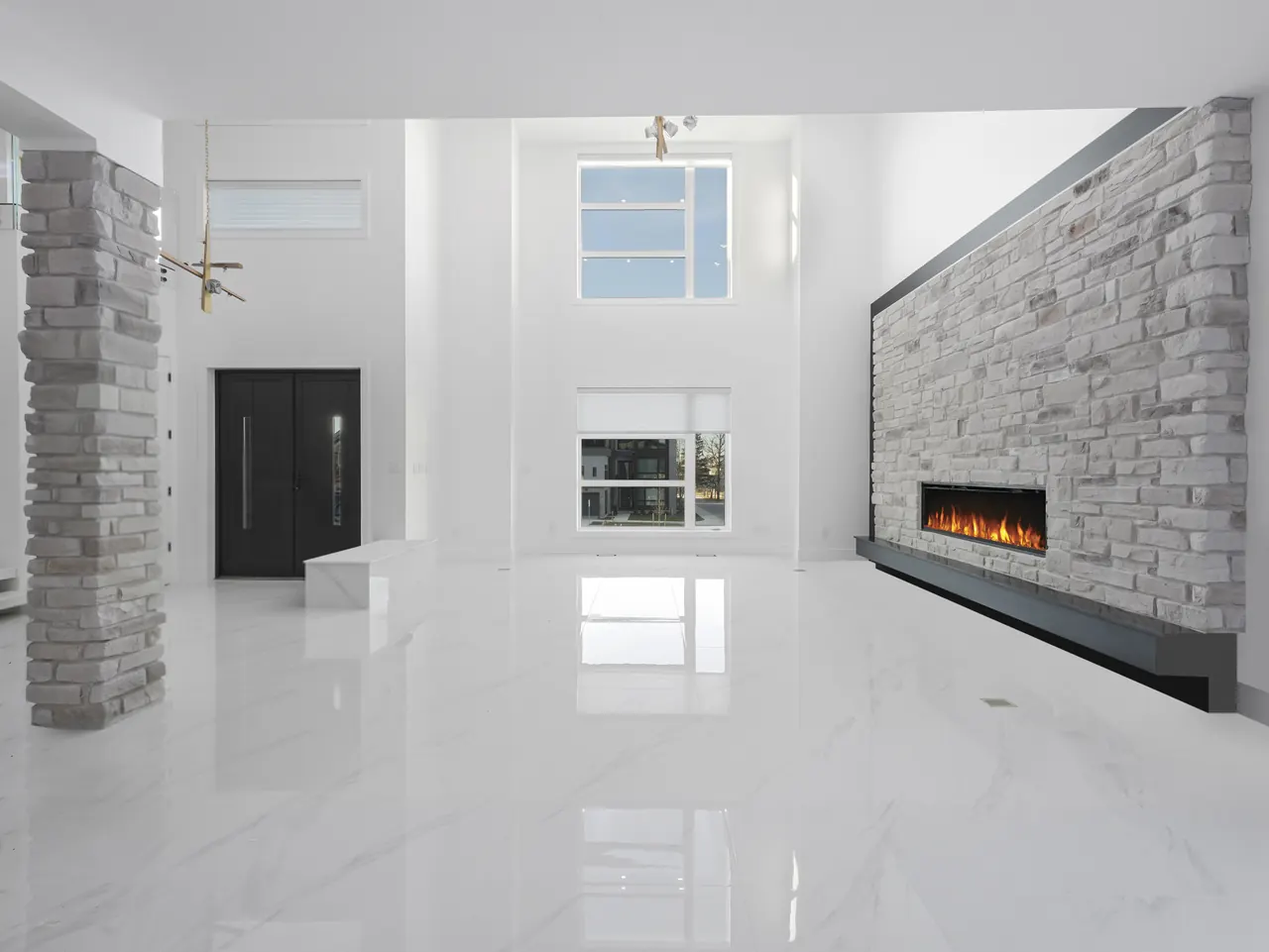 Double-height great room with a stone fireplace wall