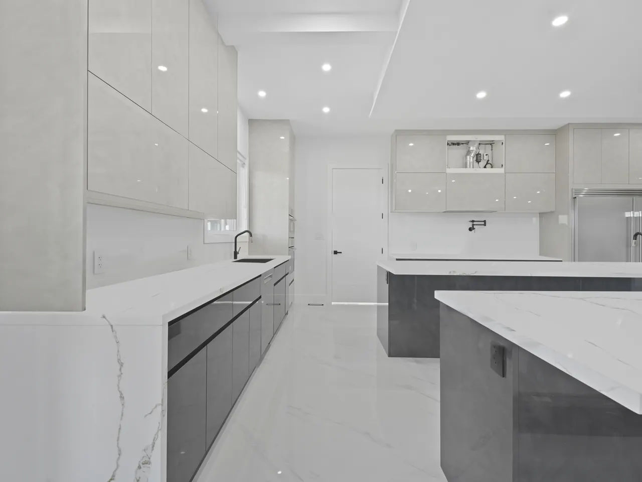 Kitchen with quartz waterfall island and high-gloss cabinets