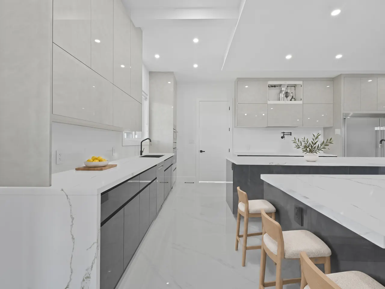 Kitchen with quartz waterfall island and high-gloss cabinets, virtually staged with three counter stools
