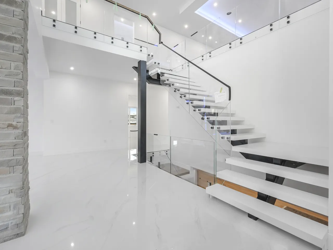 Floating staircase with glass railings in a double-height entry